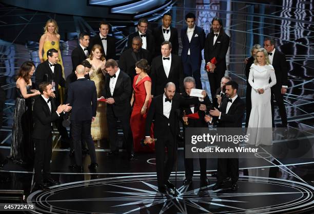 La La Land' producer Jordan Horowitz holds up the winner card reading actual Best Picture winner 'Moonlight' with actor Warren Beatty onstage during...