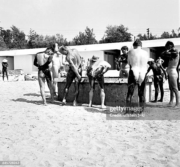 Männer reiben sich mit Moorschlamm ein hier 1966 - eingescannt