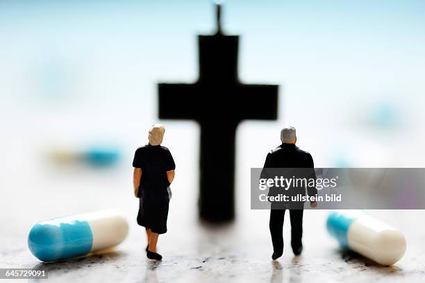 Miniaturfiguren, Kreuz und Tabletten, Symbolfoto Sterbehilfe