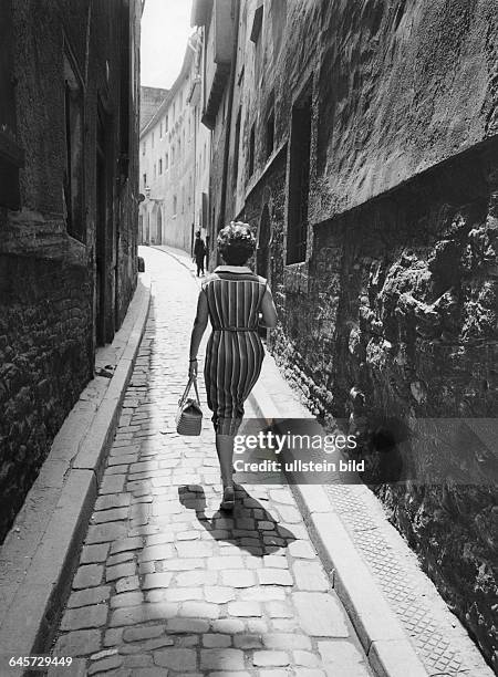 Frau geht eine Gasse hinauf, 50er Jahre