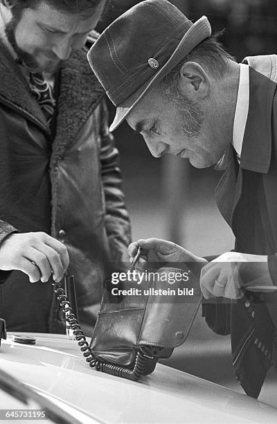 Kriminalpolizisten bei Spurensicherung am Funkgerät. Berlin , 27. 02. 1975. Spurensicherung am Tatort Quermatenweg. Terroristen der Bewegung 2. Juni...