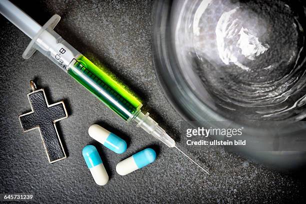 Wasserglas, Kreuz, Tabletten und Spritze, Symbolfoto Sterbehilfe