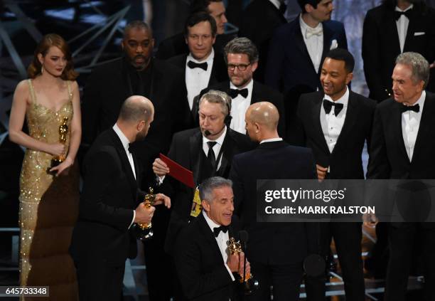 La La Land" producer Jordan Horowitz speaks to stage manager Gary Natoli , reading the winners card, after "La La Land" mistakenly won the best...