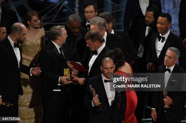 An Oscar show producer shows the winners card to the cast of "La La Land" after it mistakenly won the best picture instead of "Moonlight" at the 89th...