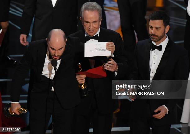 "La La Land" producer Jordan Horowitz shows the card saying "Moonlight" won the best picture as actor Warren Beatty , and Host Jimmy Kimmel look on...