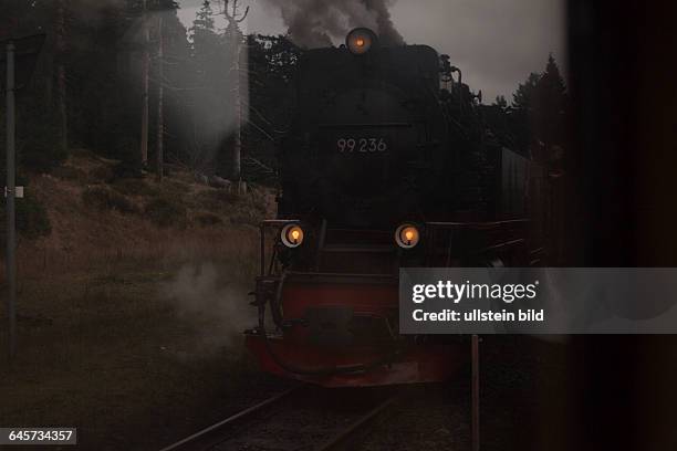 Die von einer Dampflok gezogene Schmalspurbahn fährt bis auf den Gipfel des Brocken und wieder hinunter. Blick aus dem Fenster des Zuges auf eine...