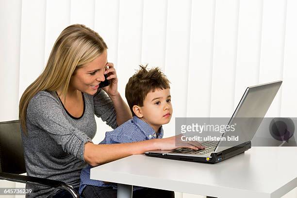 Mutter und Sohn am Computer, Symbol für Heimarbeit, Familie und Beruf, Doppelbelastung