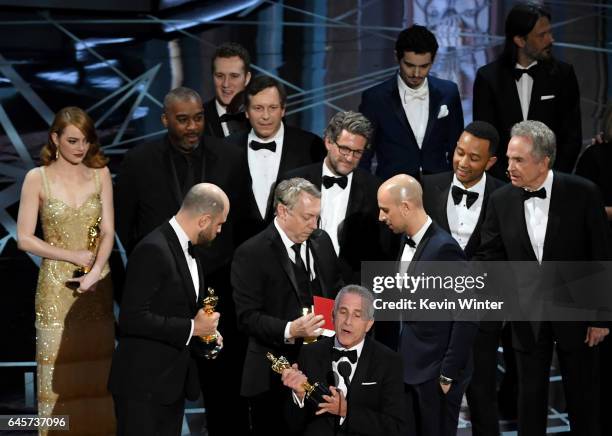 La La Land' producer Marc Platt speaks with producers Jordan Horowitz and Fred Berger as production staff consult behind them regarding a...