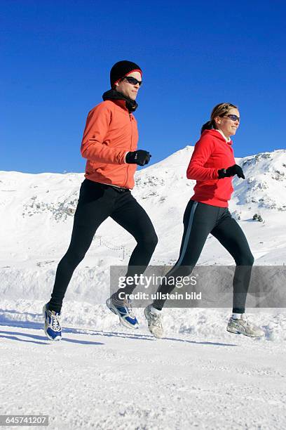 Mann und Frau joggen im Winter