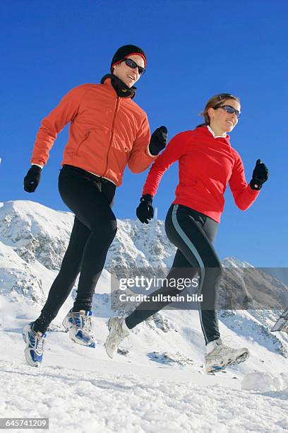 Mann und Frau joggen im Winter