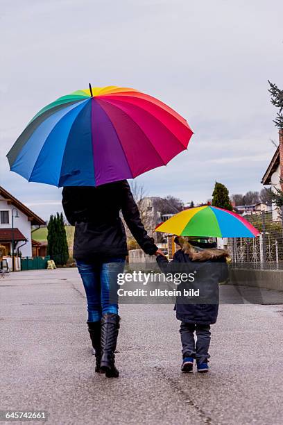 Mutter und Kind mit Regenschirm, Symbol für Solidarität, Hilfe, Hilfspaket, Rettungsschirm