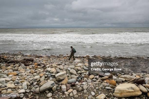 Beachcomber walks along a formerly sandy beach, but now rocky shoreline at Refugio State Park, on February 20 in Refugio Beach, California. Following...