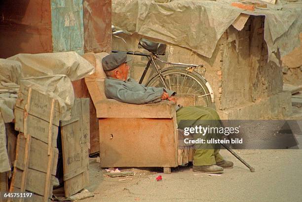 Ein Mann in einem Sessel im Stadtgebiet nahe dem Tiananmen - Platz in Peking, China, aufgenommen im April 1996.