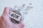 401k retiring plan concept with hand holding a glass jar