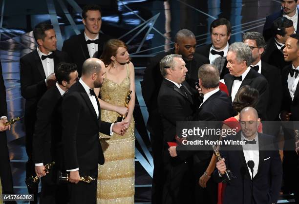 La La Land' producer Fred Berger speaks at the microphone as production staff consult behind him regarding a presentation error of the Best Picture...