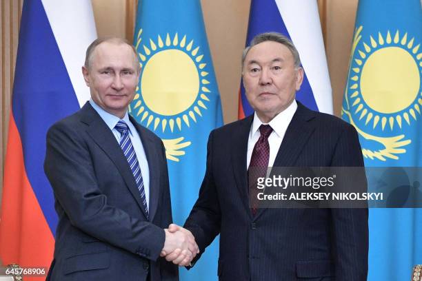 Russian President Vladimir Putin shakes hands with his Kazakh counterpart Nursultan Nazarbayev during a meeting in Almaty on February 27, 2017.