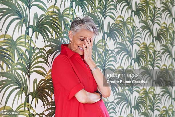 portrait of senior woman laughing - vrouw behangen stockfoto's en -beelden
