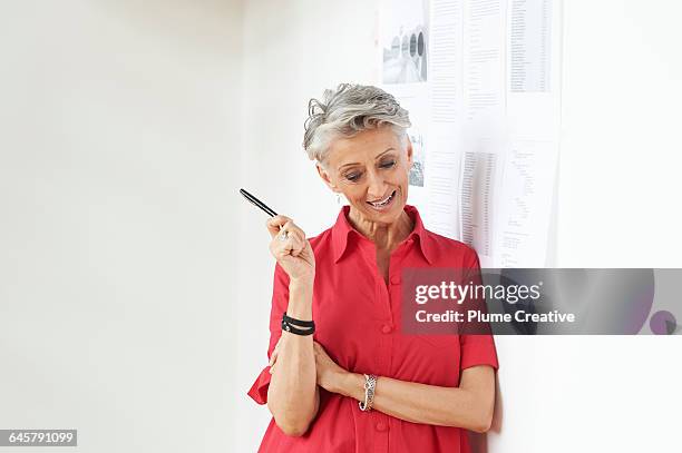 senior woman running a meeting - red dress shirt stock pictures, royalty-free photos & images