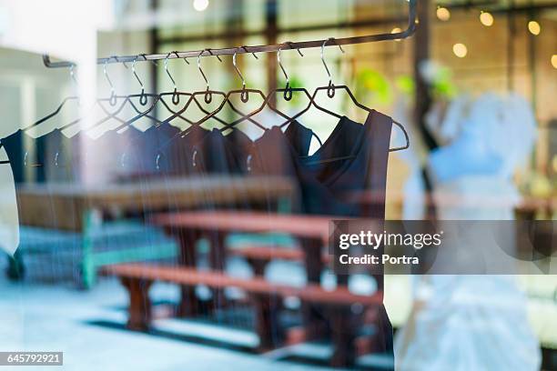 black dresses arranged on clothes rack - ショーウィンドウ ストックフォトと画像