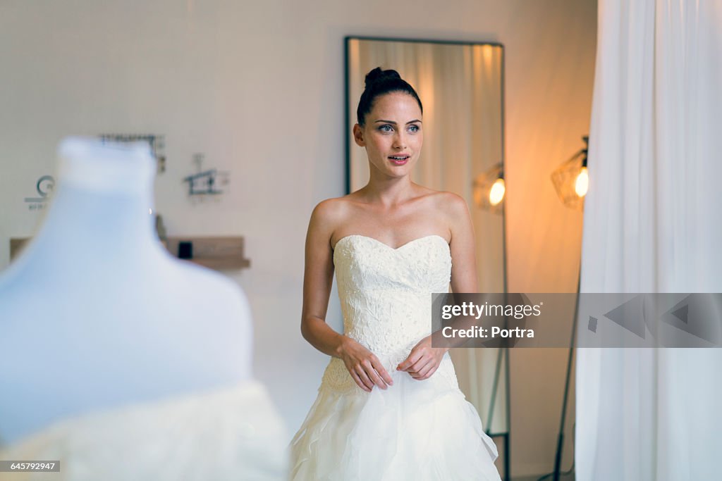 Woman wearing wedding gown at bridal shop