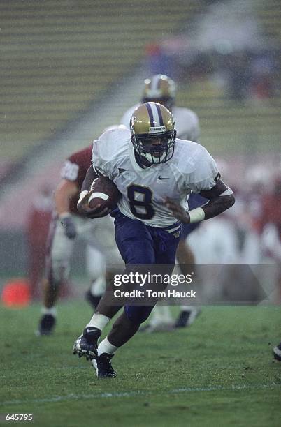 Willie Hurst of the Washington Huskies runs with the ball during the game against the Stanford Cardinal at Palo Alto, California. The Huskies...