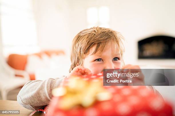 happy boy opening christmas present at home - christmas gift stock pictures, royalty-free photos & images