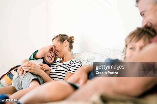 smiling parents are embracing sons at home - child laughing imagens e fotografias de stock