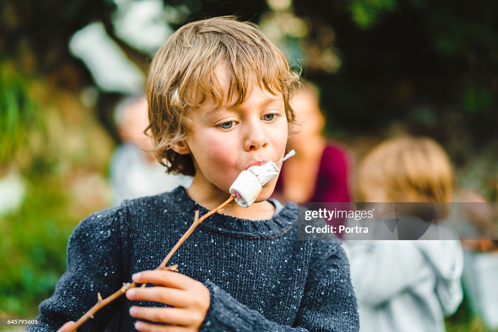 Boy eating marshmallows while looking down