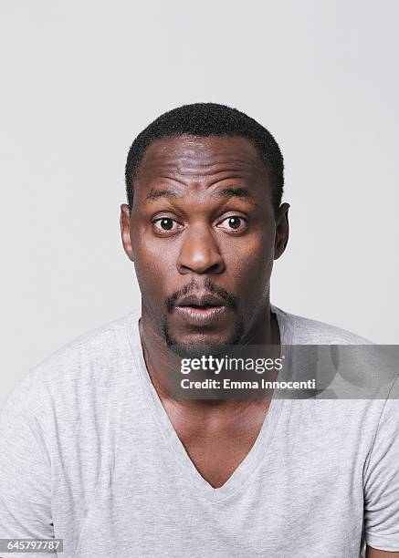 studio portrait of surprised man with goaty beard - v neck stock-fotos und bilder