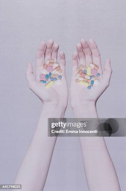 two open hands holding medicine - hand holding several pills photos et images de collection