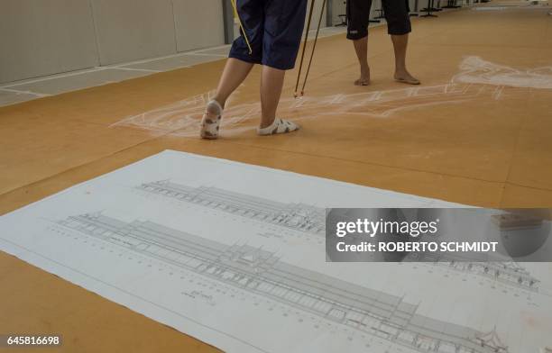 In this picture taken on February 23 artists use chalk to trace designs that will be used on an enormous largely wooden funeral pyre for the late...