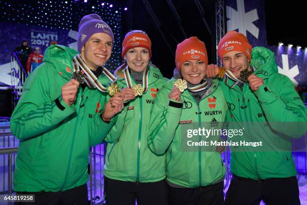 Markus Eisenbichler, Carina Vogt, Svenja Wuerth and Andreas Wellinger of Germany celebrate with their gold medals after victory in the Mixed Team...