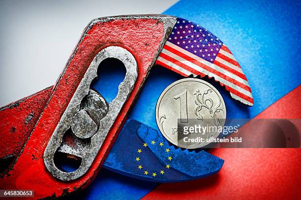 Ein-Rubel-Münze vor russischer Fahne in der Zange von USA und EU, Sanktionen gegen Russland