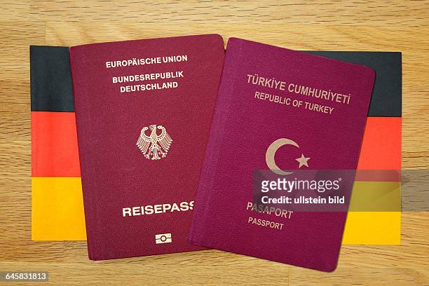 Deutscher und türkischer Reisepass auf Deutschlandfahne, doppelte Staatsbürgerschaft