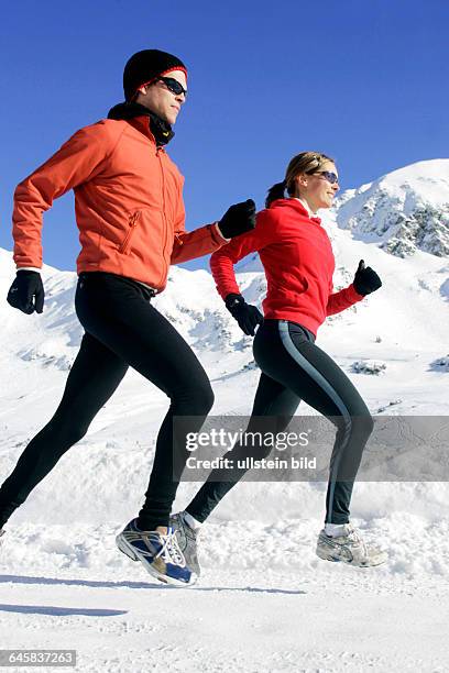 Mann und Frau joggen im Winter