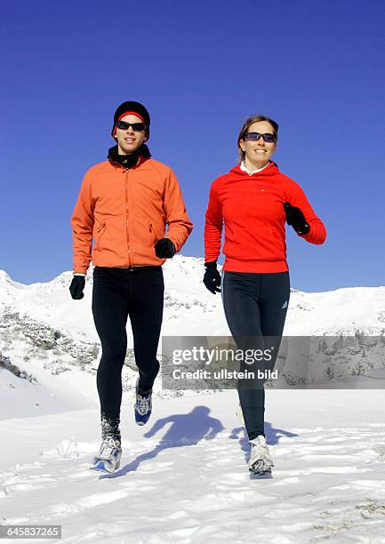 Mann und Frau joggen im Winter