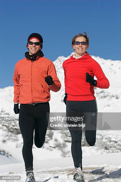 Mann und Frau joggen im Winter