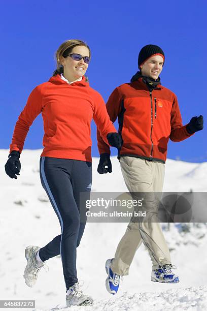 Mann und Frau joggen im Winter