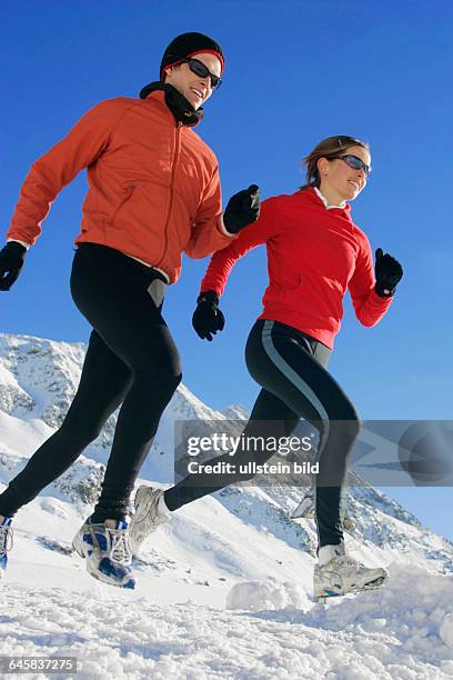 Mann und Frau joggen im Winter