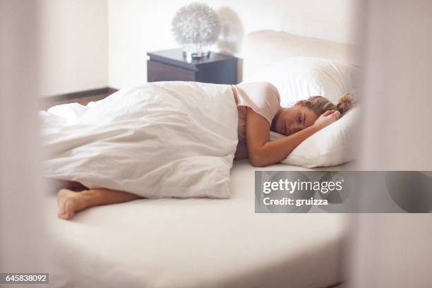 jonge alleenstaande vrouw in bed thuis in de ochtend - yawning woman stockfoto's en -beelden