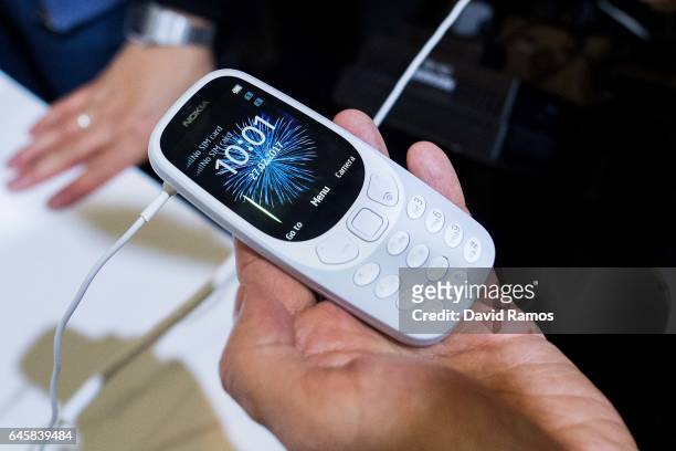 Visitors look at the new Nokia 3310 during the Mobile World Congress 2017 on the opening day of the event at the Fira Gran Via Complex on February...