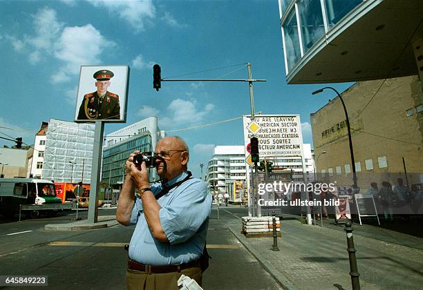 Check Point Charlie, Friedrichstrasse, Tourist fotografiert vor Bildnis eines russischen Soldaten, altes Sektorenschild