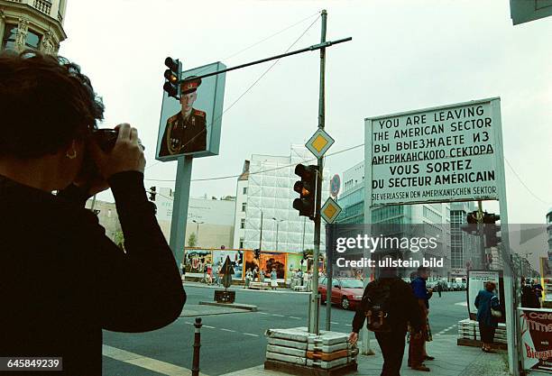 Check Point Charlie, Friedrichstrasse, Touristin fotografiert Bildnis eines russischen Soldaten, altes Sektorenschild