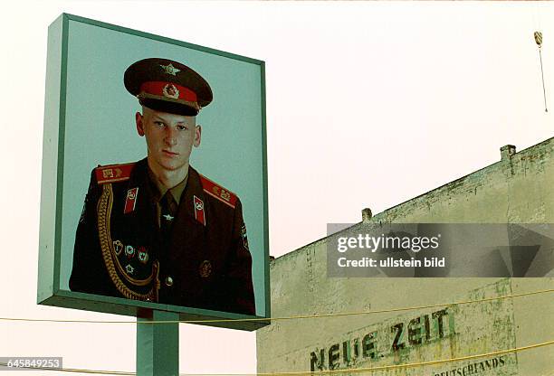 Check Point Charlie, Friedrichstrasse, Bildnis eines russischen Soldaten, im Hintergrund Reklame fuer die ehem. CDU - Zeitung "Neue Zeit" DEU, Berlin,