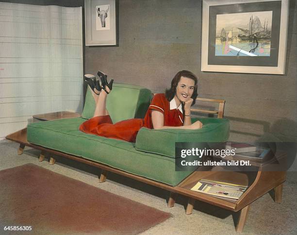 Young woman presenting a modern living roompublished in "Die Hausfrau" 6/1954