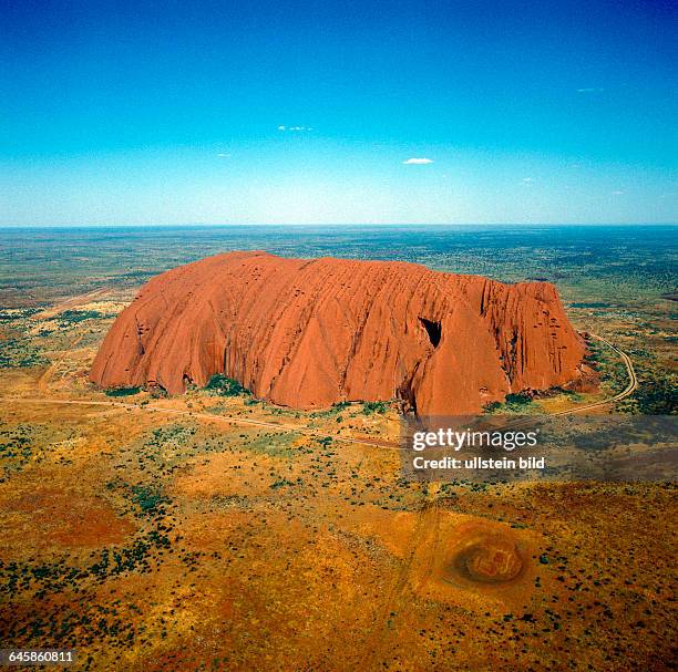 Luftaufnahme des Ayers Rock oder Uluru, riesiger Sandsteinmonolith aus dem Praekambrium und heiliger Berg der Aborigines, ein Naturwunder im roten...