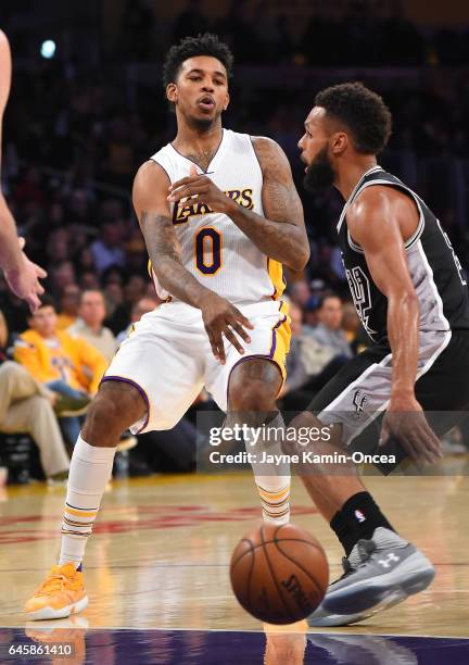 Patty Mills of the San Antonio Spurs guards Nick Young of the Los Angeles Lakers as he passes the ball during the game at Staples Center on February...