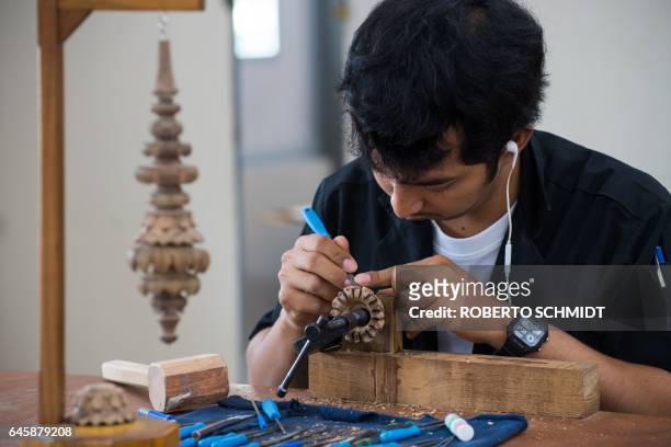 In this picture taken on February 23 a wood artist works on wooden pieces that will form part of intricate designs that will be used on an enormous...