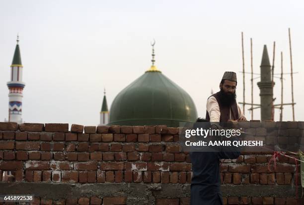 Pakistan follower gets free food in front of the tomb of Mumtaz Qadri, who was hanged last year for the murder of a governor who criticized...