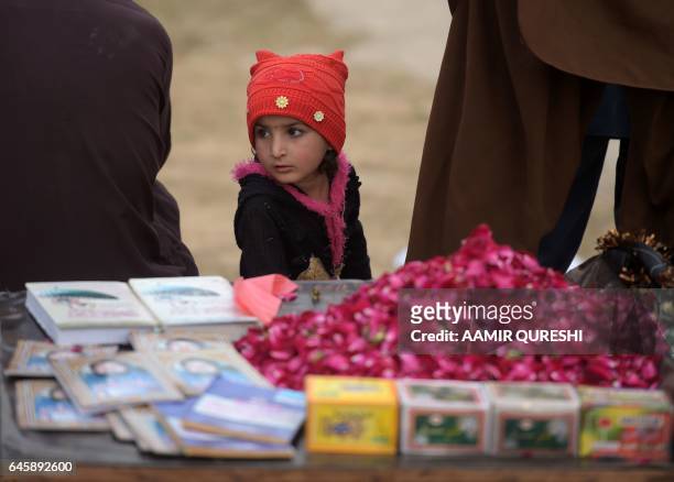 Young Pakistani child sells rose petals outside the tomb of Mumtaz Qadri, who was hanged last year for the murder of a governor who criticized...